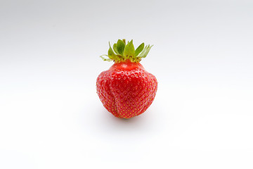 One red strawberry Asia irregular shape isolated on white background, close up
