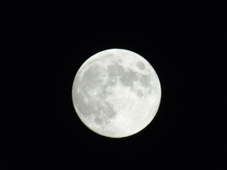 An amazing photography of the full moon over the city of Genova by night with a great clear sky in background and some stars