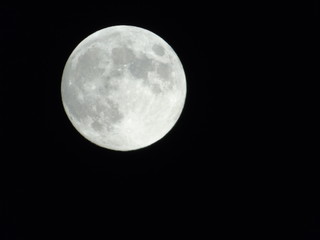 An amazing photography of the full moon over the city of Genova by night with a great clear sky in background and some stars