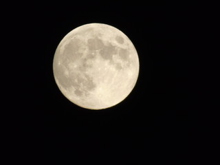 An amazing photography of the full moon over the city of Genova by night with a great clear sky in background and some stars