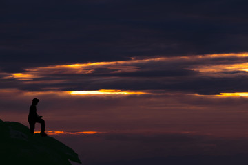 Fototapeta na wymiar Silhouette Man Standing On Mountain Against Sky During Sunset