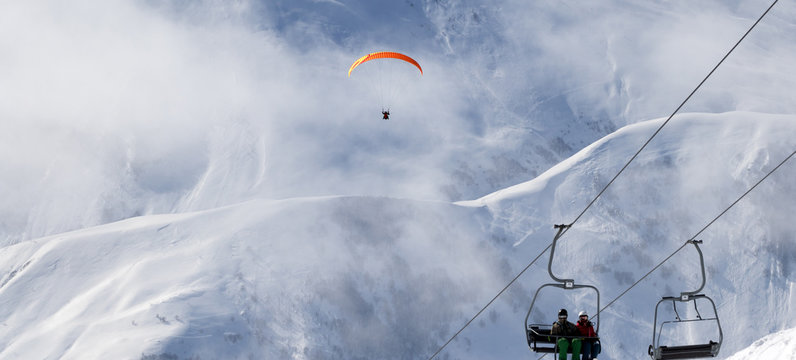 Chair-lift and paraplane on ski resort at cold winter day