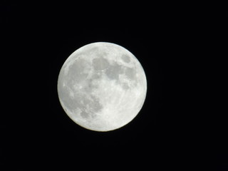 An amazing photography of the full moon over the city of Genova by night with a great clear sky in background and some stars
