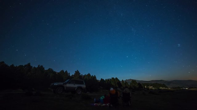 Timelapse of tourists camping in La Cerdanya, Pyrenees, Spain, enjoying the night sky and turning on a flashlight
