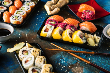 Sushi Set sashimi and sushi rolls served on stone slate
