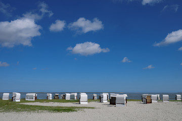 Panorama mit Strandkörben und Sandstrand und blauer Himmel im Urlaub an der Nordseeküste - Stockfoto