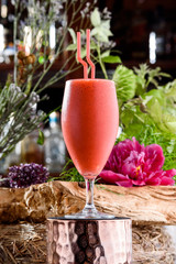 milkshake in beautiful glass on the background of fresh flowers. Summer drink