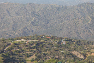 Traditional rural greek scenic mountaine view, olives and other trees grow on slopes, houses with red roofs