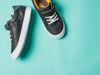 pair of new kids or adult sneakers on blue background, top view. Flat lay gray and yellow or...