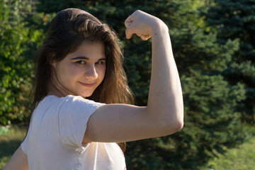 Young girl shows muscles