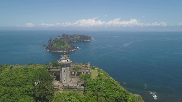 Aerial view lighthouse in Palau island. Lighthouse in cape Engano against blue sky and rocky islands, province of Cagayan, Philippines.