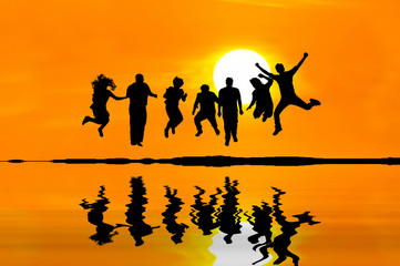 Fototapeta na wymiar Silhouette of happy people jumping over sunset, concept about having fun