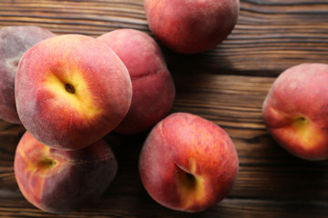 Bunch of ripe organic peaches in pile on textured table background. Local produce harvest heap on vintage style countertop. Clean eating concept. Top view, close up, copy space for text.