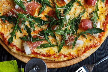 Pizza slice with bacon and greens close-up