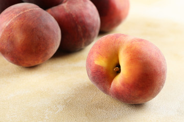 Bunch of ripe organic peaches in pile on textured table background. Local produce harvest heap on vintage style countertop. Clean eating concept. Top view, close up, copy space for text.