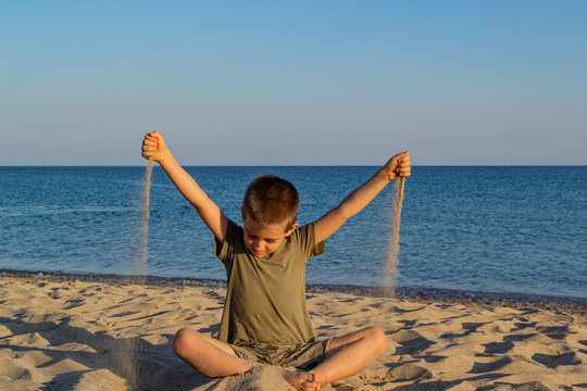 Sports child does yoga and meditates on the beach. The sandy beach is quiet and peaceful. Copy space.