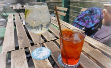Two glasses with a cocktail on the background of the canals of Milan.