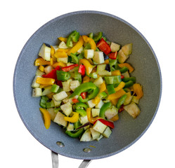 Mixed raw sliced vegetables in a pan, isolated