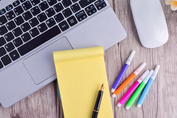 Laptop, notebook with magnifying glass on wooden table