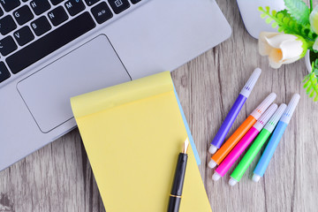 Laptop, notebook with magnifying glass on wooden table