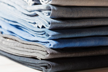 Stack of jeans in different colors.