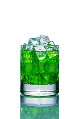Crystal glass filled with ice and green lemonade on a white background with reflection