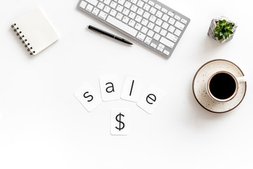 Office desk with notebook, sale word and dollar sign on white background top view