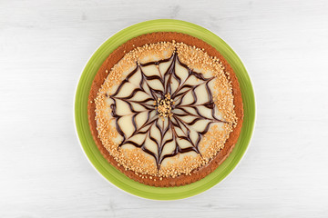 White chocolate tart decorated with hazelnut grain.