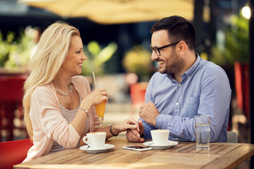 Happy couple in love communicating while being in a cafe.