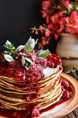 Homemade American pancakes covered with raspberry syrup