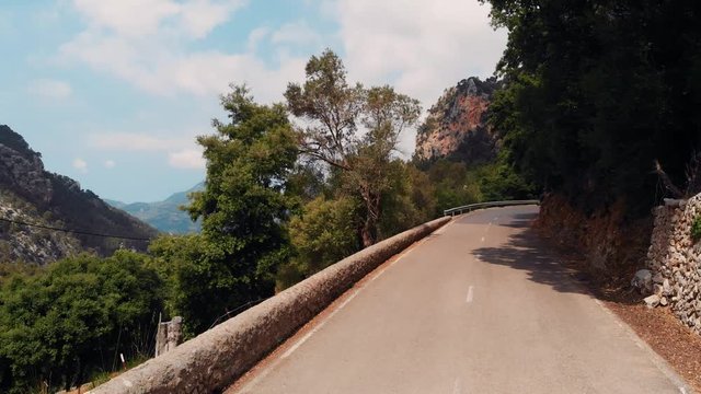 AERIAL Pedesta upl from empty road to reveal forested canyon in Mallorca in Spain