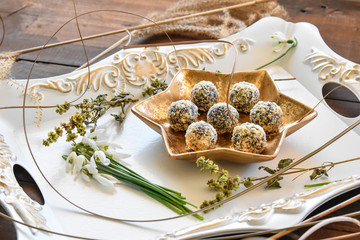 Yummy dessert balls with datepalm and walnuts in gold arrangement.