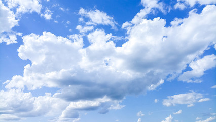 Naklejka na ściany i meble Cumulus clouds against a bright blue sky on a Sunny day.