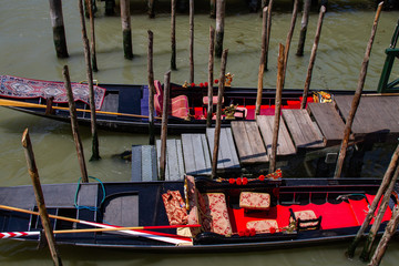 Fototapeta na wymiar Empty Gondolas by the pier on the Venice canal in Italy