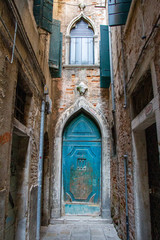 Fototapeta na wymiar Blue door at the end of an alley in Venice, Italy