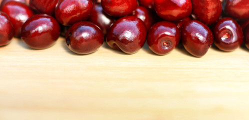 Fruits. Ripe red sweet cherry on a light wooden background.