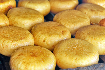 smoked cheese in wooden grill oven of smokehouse closeup view of traditional homemade food made from milk diary product production process