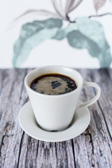 a cup of black coffee on wooden table