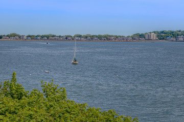 sailboat in ocean with land in background