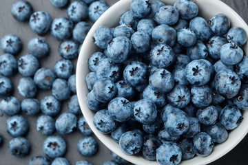 Fresh selected blueberries in bowl on dark gray table background