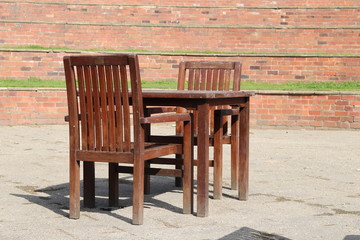A wooden table and chairs in a brick amphitheater 