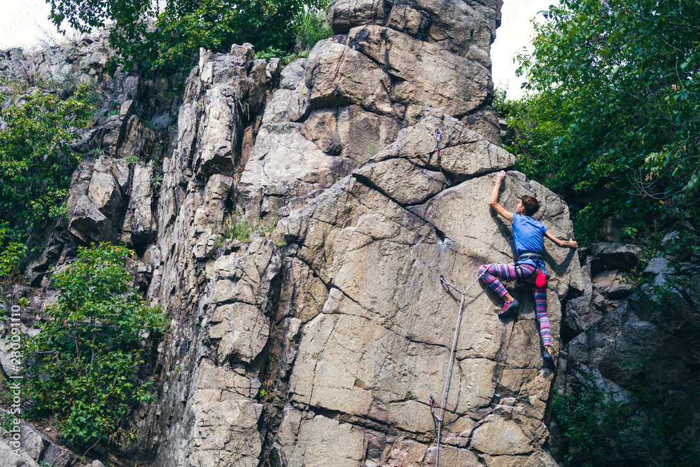 Sticker the girl climbs the granite rock.