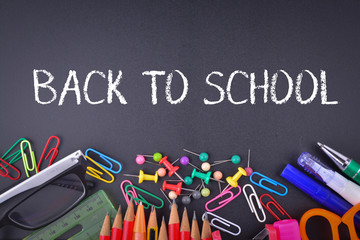 School supplies on chalkboard with text Back to School