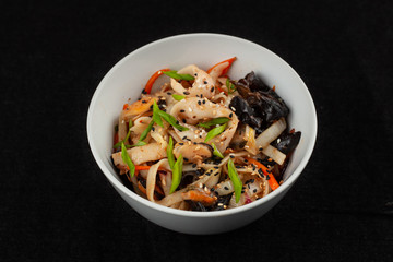 Thai wok wheat noodle with bell pepper, onion, omelette and shiitake mushrooms, isolated on black background