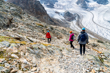 Naklejka premium Young climbers on their way to ferrata Piz Trovat. Morteratsch Glacier. Panorama of Piz Bernina in Swiss Alpes.