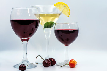 Martini with olive and lemon slice. Red wine in a glass. A slice of lemon and cherry as a decoration for a drink.