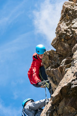 Young hikers climb on the ferrata Piz Trovat. Morteratsch Glacier. Panorama of Piz Bernina in Swiss Alpes.