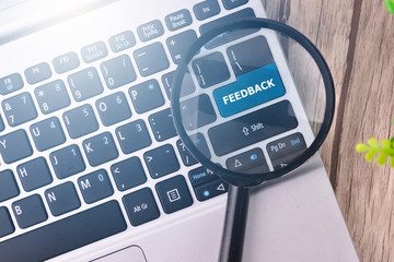 FEEDBACK word written on keyboard view with magnifier glass