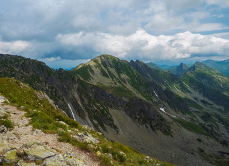 View from Banikov peak on Western Tatra mountains or Rohace panorama. Sharp green mountains - ostry rohac, placlive and volovec with hiking trail on ridge. Summer blue sky white clouds.