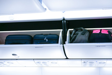 Airplane cabine with the luggage compartments,luggage ready for departure on board aircraft